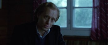 Movie still from “Headhunters” (2011), directed by Morten Tyldum – A person sitting in front of a window; Close Up shot, Over the shoulder angle