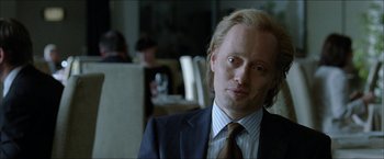 Movie still from “Headhunters” (2011), directed by Morten Tyldum – A person wearing a suit and tie; Close Up shot, Over the shoulder angle