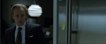 Movie still from “Headhunters” (2011), directed by Morten Tyldum – A man in a suit standing in front of an open refrigerator; Close Up shot, Over the shoulder angle