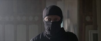 Movie still from “Headhunters” (2011), directed by Morten Tyldum – A man wearing a black balaclava is looking at the camera; Close Up shot, Over the shoulder angle