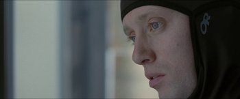 Movie still from “Headhunters” (2011), directed by Morten Tyldum – A person's face with blue eyes; Close Up shot, Over the shoulder angle