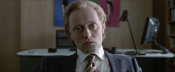 Movie still from “Headhunters” (2011), directed by Morten Tyldum – A person wearing a suit and tie; Close Up shot, Low angle