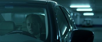 Movie still from “Headhunters” (2011), directed by Morten Tyldum – A man sitting in the back seat of a car at night; Close Up shot, Over the shoulder angle