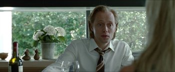 Movie still from “Headhunters” (2011), directed by Morten Tyldum – A man sitting at a table with a glass of wine; Close Up shot, Over the shoulder angle
