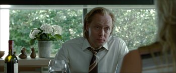 Movie still from “Headhunters” (2011), directed by Morten Tyldum – A man in a white dress shirt and a brown tie; Close Up shot, Over the shoulder angle