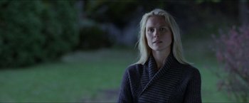 Movie still from “Headhunters” (2011), directed by Morten Tyldum – A woman with blonde hair is standing outside; Close Up shot, Over the shoulder angle