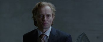 Movie still from “Headhunters” (2011), directed by Morten Tyldum – A person wearing a suit and tie; Close Up shot, Over the shoulder angle