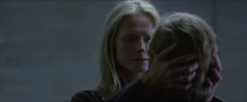 Movie still from “Headhunters” (2011), directed by Morten Tyldum – A woman with long blonde hair is holding a cat; Close Up shot, Over the shoulder angle