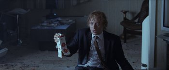 Movie still from “Headhunters” (2011), directed by Morten Tyldum – A man in a suit and tie holding a box; Medium shot, High angle