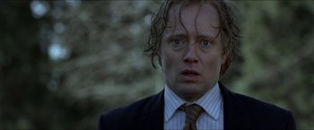 Movie still from “Headhunters” (2011), directed by Morten Tyldum – A person wearing a suit and tie; Close Up shot, Over the shoulder angle