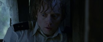 Movie still from “Headhunters” (2011), directed by Morten Tyldum – A person wearing a white shirt; Close Up shot, Low angle