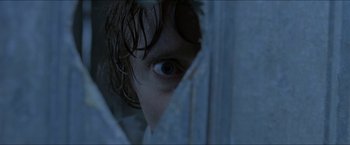 Movie still from “Headhunters” (2011), directed by Morten Tyldum – A person's eye looking through a curtain; Extreme Close Up shot, Over the shoulder angle