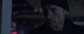 Movie still from “Headhunters” (2011), directed by Morten Tyldum – A person wearing a black hat; Close Up shot, Low angle