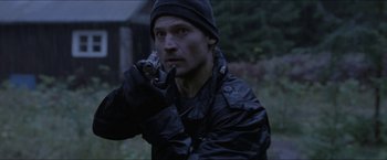 Movie still from “Headhunters” (2011), directed by Morten Tyldum – A man in a black jacket holding a cell phone to his ear; Medium shot, Over the shoulder angle