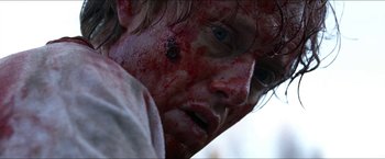 Movie still from “Headhunters” (2011), directed by Morten Tyldum – A person's face covered in blood; Close Up shot, Over the shoulder angle