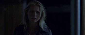 Movie still from “Headhunters” (2011), directed by Morten Tyldum – A woman with long blonde hair standing in the dark; Close Up shot, Over the shoulder angle