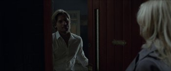 Movie still from “Headhunters” (2011), directed by Morten Tyldum – A man in a white shirt standing in front of a door; Medium shot, Over the shoulder angle