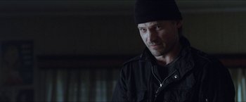 Movie still from “Headhunters” (2011), directed by Morten Tyldum – A person wearing a jacket and a hat; Close Up shot, Over the shoulder angle