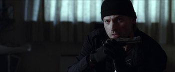 Movie still from “Headhunters” (2011), directed by Morten Tyldum – A man holding a gun in a room; Close Up shot, Over the shoulder angle