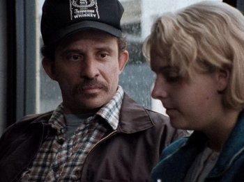 Movie still from “Henry: Portrait of a Serial Killer” (1986), directed by John McNaughton – A man and a woman standing next to each other; Close Up shot, Over the shoulder angle