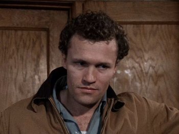 Movie still from “Henry: Portrait of a Serial Killer” (1986), directed by John McNaughton – A person with curly hair; Close Up shot, High angle
