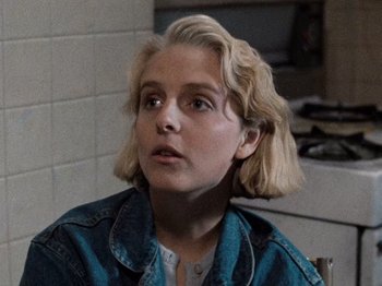 Movie still from “Henry: Portrait of a Serial Killer” (1986), directed by John McNaughton – A woman with blonde hair and a blue jean jacket; Close Up shot, Over the shoulder angle