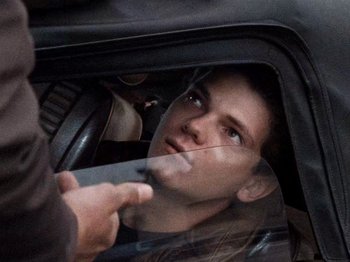 Movie still from “Henry: Portrait of a Serial Killer” (1986), directed by John McNaughton – A man in the back seat of a car looking out the window; Close Up shot, Over the shoulder angle