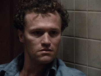 Movie still from “Henry: Portrait of a Serial Killer” (1986), directed by John McNaughton – A person with curly hair; Close Up shot, Low angle