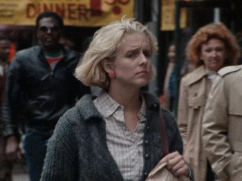 Movie still from “Henry: Portrait of a Serial Killer” (1986), directed by John McNaughton – A woman walking down a street holding a purse; Close Up shot, Over the shoulder angle