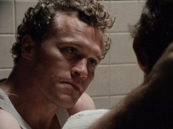 Movie still from “Henry: Portrait of a Serial Killer” (1986), directed by John McNaughton – A person in a bathroom mirror; Close Up shot, Over the shoulder angle
