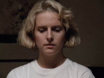 Movie still from “Henry: Portrait of a Serial Killer” (1986), directed by John McNaughton – A young woman with blonde hair wearing a white t - shirt; Close Up shot, Low angle