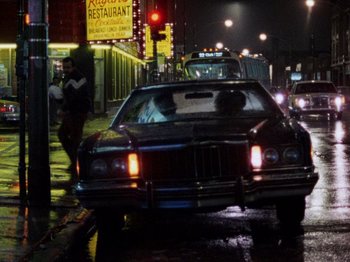 Movie still from “Henry: Portrait of a Serial Killer” (1986), directed by John McNaughton – A car parked on the side of the road at night; Wide shot, Low angle