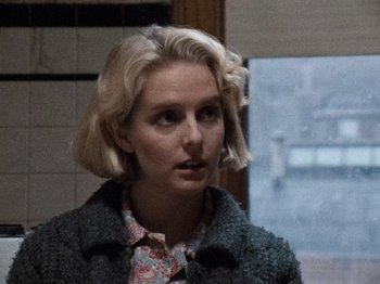 Movie still from “Henry: Portrait of a Serial Killer” (1986), directed by John McNaughton – A woman with blonde hair wearing a floral shirt; Close Up shot, Over the shoulder angle