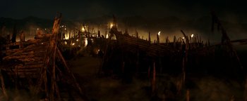 Movie still from “Hercules” (2014), directed by Brett Ratner – A group of people standing next to a wooden boat at night; Extreme Wide shot, High angle