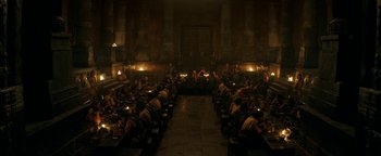 Movie still from “Hercules” (2014), directed by Brett Ratner – A group of people sitting at a table in a room; Extreme Wide shot, High angle