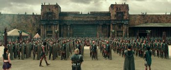 Movie still from “Hercules” (2014), directed by Brett Ratner – A large group of men in roman garb standing in front of a building; Extreme Wide shot, High angle