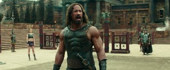 Movie still from “Hercules” (2014), directed by Brett Ratner – A man with a sword in his hand and a leather vest; Medium shot, Over the shoulder angle