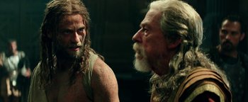 Movie still from “Hercules” (2014), directed by Brett Ratner – A man with long hair and a beard standing next to an older man with long white hair; Medium shot, Over the shoulder angle