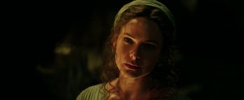 A beautiful woman with curly brown hair wearing a green head scarf