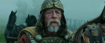 Movie still from “Hercules” (2014), directed by Brett Ratner – An old man with a beard wearing a helmet; Close Up shot, Low angle