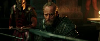 Movie still from “Hercules” (2014), directed by Brett Ratner – A person with a sword in a room; Close Up shot, Over the shoulder angle
