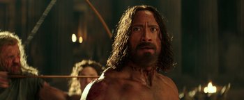 Movie still from “Hercules” (2014), directed by Brett Ratner – A man with long hair and a beard is looking at the camera; Close Up shot, Over the shoulder angle