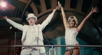 Movie still from “High School Musical 3: Senior Year” (2008), directed by Kenny Ortega – A man and a woman are waving their hands in the air; Wide shot, Low angle