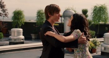 Movie still from “High School Musical 3: Senior Year” (2008), directed by Kenny Ortega – A man and a woman embracing each other outside; Medium shot, Over the shoulder angle