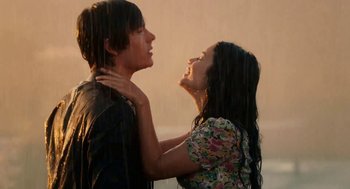 A man and a woman standing in the rain