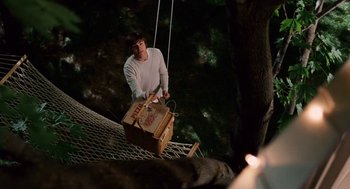 Movie still from “High School Musical 3: Senior Year” (2008), directed by Kenny Ortega – A man holding a box while standing on top of a rope; Wide shot, High angle