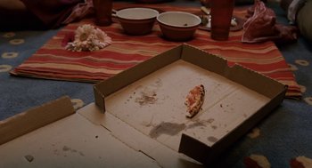 Movie still from “High School Musical 3: Senior Year” (2008), directed by Kenny Ortega – A pizza sitting on top of a cardboard box on the floor; Extreme Close Up shot, High angle