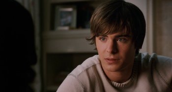 Movie still from “High School Musical 3: Senior Year” (2008), directed by Kenny Ortega – A young man sitting in front of a fireplace; Close Up shot, Over the shoulder angle