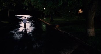 Movie still from “High School Musical 3: Senior Year” (2008), directed by Kenny Ortega – A man walking down a street at night; Extreme Wide shot, High angle
