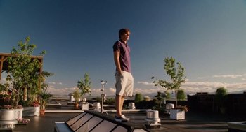Movie still from “High School Musical 3: Senior Year” (2008), directed by Kenny Ortega – A man standing on top of a building on top of a roof; Wide shot, Low angle